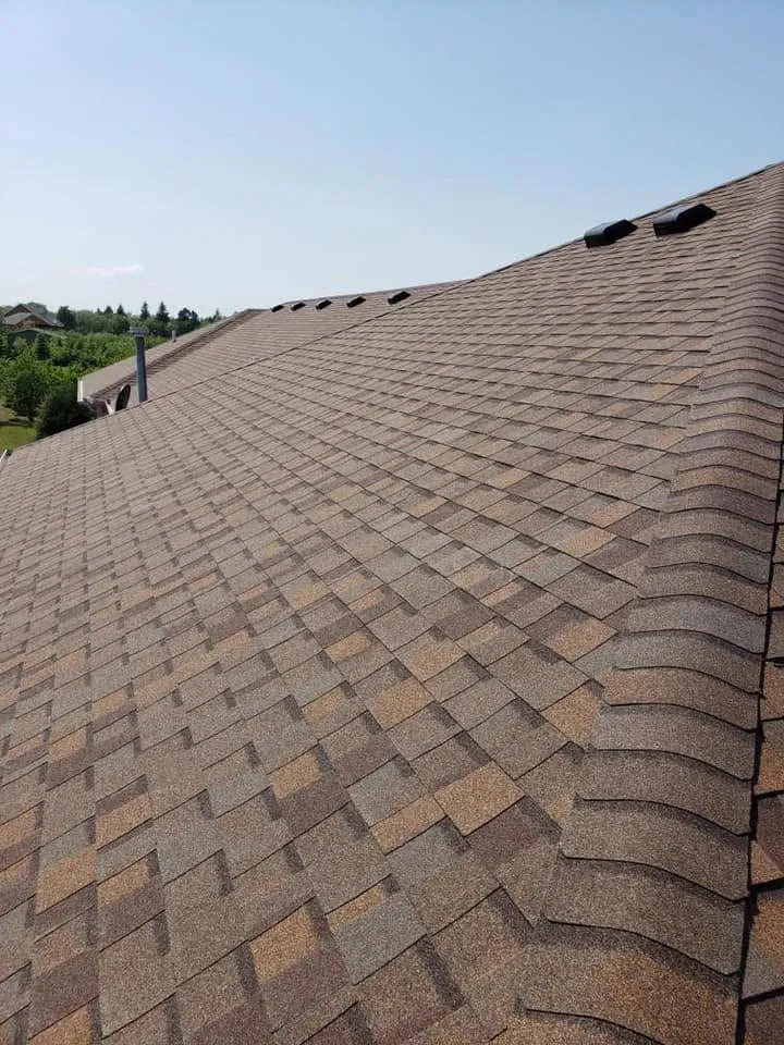 Close-up of a warm brown architectural-shingle roof along the ridge
