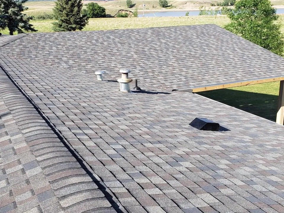 Close-up of a finished multi-tone asphalt-shingle roof with vents